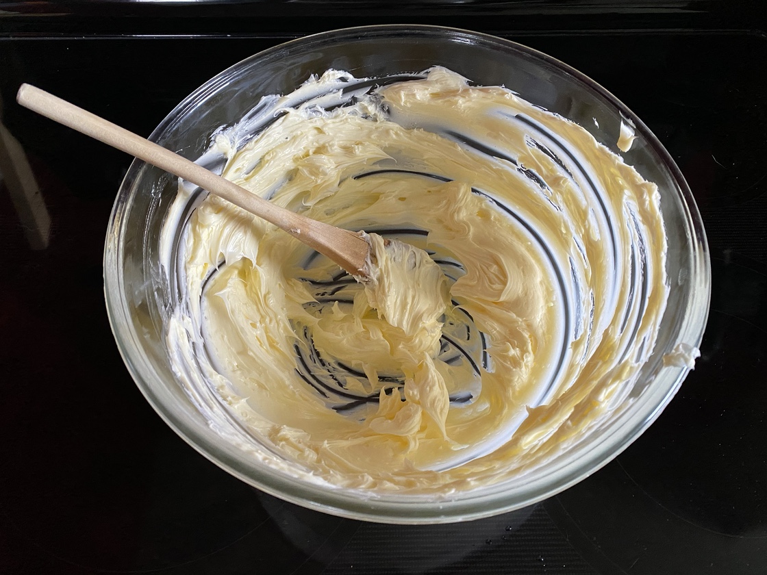 Butter in a large glass mixing bowl that has been beaten until light and airy.