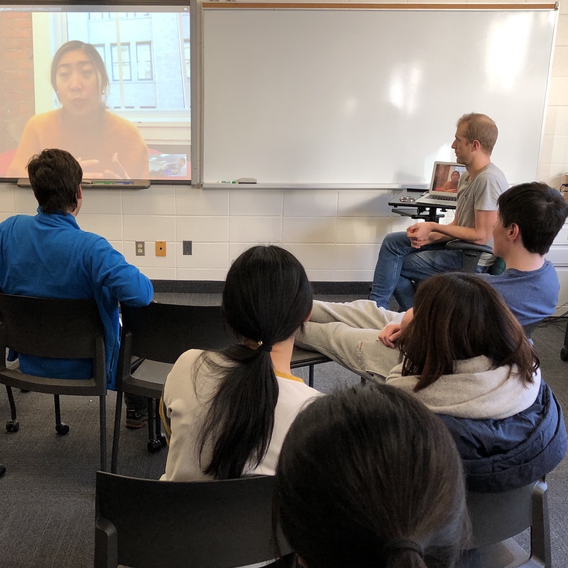 A young woman takes part in a video chat with current high school students.