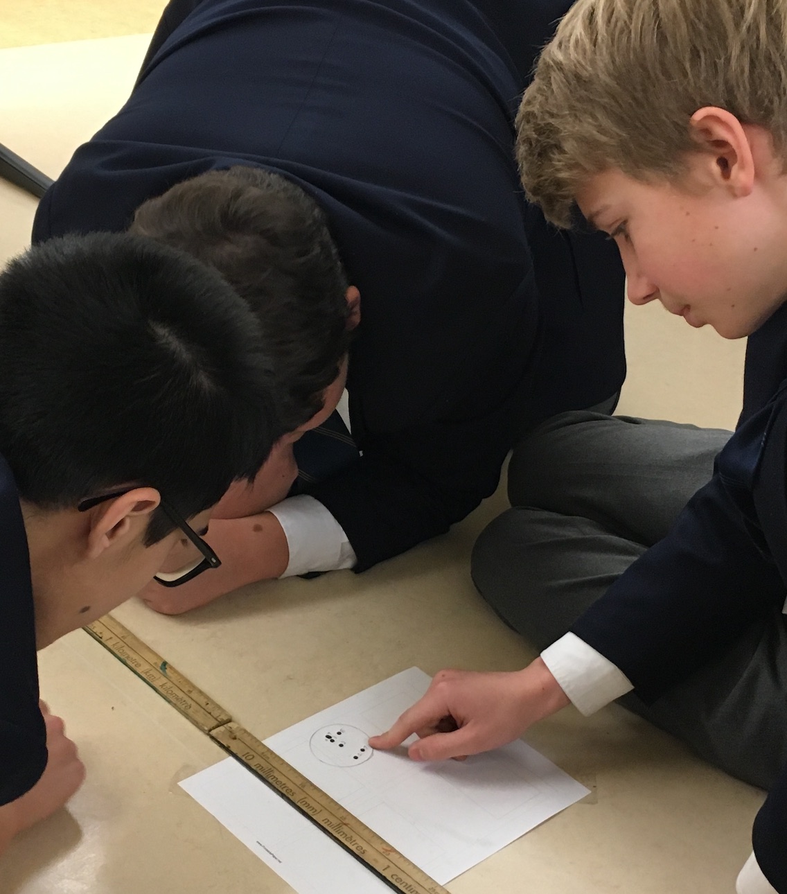 Students work together to determine the where the ball bearing hits the ground.